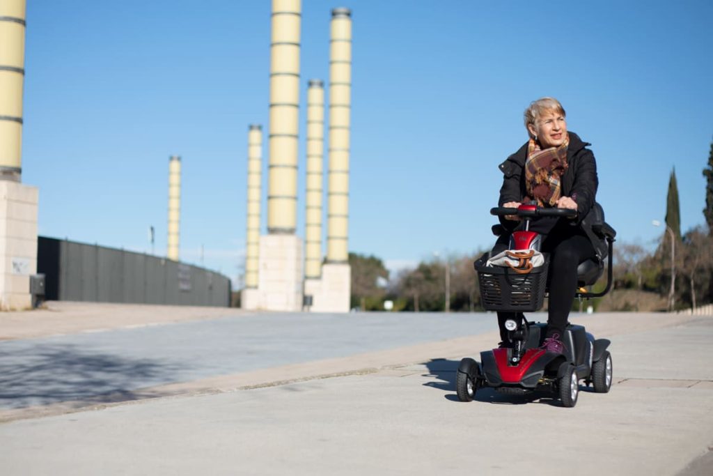 mujer conduciendo scooter por calzada
